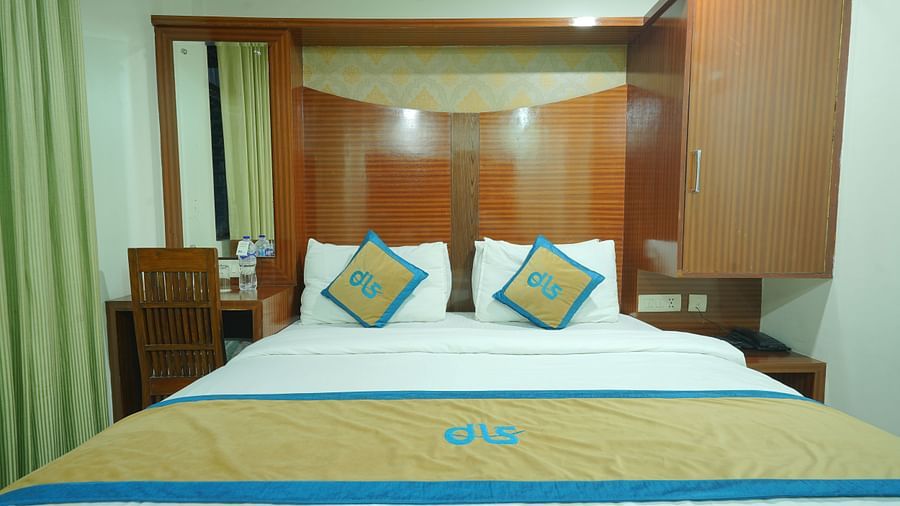 Deluxe room with a king size bed, adorned with a stylish wooden headboard at DLS Hotels The Rock Castle.